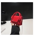 Close-up of bright red mini bag featuring crocodile texture and metallic chain strap - Red