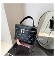 Detail view of the elegant box bag featuring monogram patterns and gold dual zippers - Black