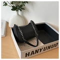 Detail of black crescent shoulder bag with waffle texture and silver chain strap - Black