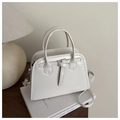 Detailed view of off-white faux leather handbag with adjustable strap and metal buckle - White