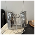 Close-up of silver wrinkled tote bag with bow detail and vintage key charm accessory - Silver With Pendant
