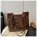 Detailed shot of dark brown glossy leather tote bag with silver chain and bow detail - Brown with Pendant