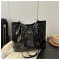 Detail of black glossy tote bag with silver bow accent and metal chain shoulder strap - Black With Pendant