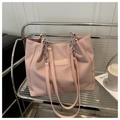 Detailed view of pink textured tote bag featuring a leather logo tag and chain strap - Pink Without Pendant
