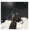 Dettaglio ravvicinato della borsa di paillettes nere con chiusura metallica a forma di S - Nero