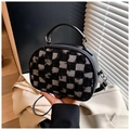 Dettaglio della borsa a mano con patchwork a scacchi bianchi e neri e cerniera in metallo - Nero