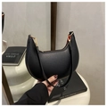 Detail of minimalist black pebbled leather crescent bag with vibrant red interior lining - Black