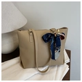 Detail of khaki tote bag with a silk scarf wrapped handle on a wooden desk - Khaki