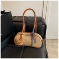 Detailansicht der gewebten Strohhandtasche mit braunen Ledergriffen und Bärenanhänger - Braun mit Anhänger