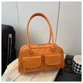 Close-up of bright orange glossy shoulder bag featuring dual front pockets and fine texture - Orange