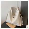 Detalle de bolso tote blanco con textura lichi y logo sobre un fondo minimalista - Blanco