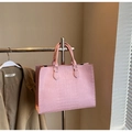 Détail du sac cabas rose gaufré crocodile avec une texture élégante et moderne - Rose