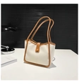 Minimalistische beige Leder-Tote-Bag mit braunem Rand auf einem Schreibtisch - Gebrochenes Weiß