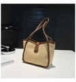 Detail der zweifarbigen Tragetasche in Beige und Braun auf einem Arbeitstisch - Khaki