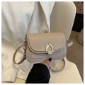 Detalle de bolso de silla beige con hebilla de metal dorada en U y correa de piel fina - Caqui