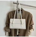 White rectangular minimalist shoulder bag with flap closure hanging on a metal rack - White Without Pendant