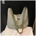 Dettaglio della borsa tote in tela verde oliva con ampia tracolla e patch logo fashion - Verde