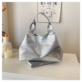 Elegante bolso tote plateado con relieve de cocodrilo sobre un libro de arte moderno - Plateado