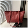Detailed close-up of burgundy woven texture and handle stitching on a large tote bag - Red