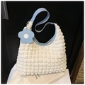 Dettaglio del tessuto a bolle bianco con finiture in pelle azzurra e ciondolo a fiore - Bianco con Blu