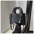 Detail of black quilted leather handbag with silver sphere charm and round handles - Black