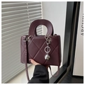 Macro detail of wine red quilted handbag with glossy finish and silver metal charms - Coffee