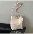 Dettaglio della borsa jacquard champagne con ricami cinesi tradizionali e nappa di seta - Rosa