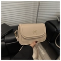 Close-up of a beige minimalist square bag with a golden metal bow buckle detail - Khaki
