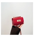 Detail showing red quilted leather mini bag with gold chain strap and rectangle lock - Red