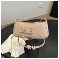Close-up of beige leather crescent bag featuring metal buckle and knotted shoulder strap - Khaki