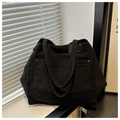 Detail of black corduroy tote bag showing textured fabric and metal rivet pocket - Black