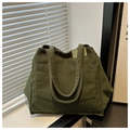 Detail of olive green corduroy tote bag showing ribbed texture and front pocket with rivets - Green