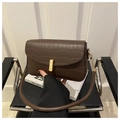 Close-up of brown crocodile texture leather bag with elegant gold cylindrical buckle - Brown