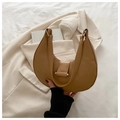 Detail of khaki crescent shoulder bag with wide strap on a white blazer and books - Khaki