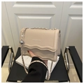 Nahaufnahme der cremefarbenen Ledertasche mit Wellenrand und eleganter Kettenschulter - Khaki