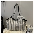 Dettaglio della borsa tote in tela a righe bianche e nere con fiocco in pizzo delicato - Bianco