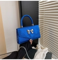 Details der königsblauen Pailletten-Handtasche mit silberner Schleife und Kette - Blau