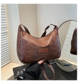 Close-up of vintage brown shoulder bag with pleated leather texture and FASHION patch - Coffee
