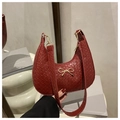Dettaglio della borsa a mezzaluna intrecciata rosso scuro con fiocco dorato e tracolla - Rosso