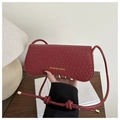 Close-up of red woven texture on crossbody bag with gold lettering and knot strap - Red