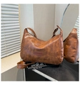 Close-up of vintage brown leather pillow bag with texture detail and fashion label - Brown