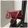 Detailed shot of dark red vintage crossbody bag featuring large silver metal rings - Red