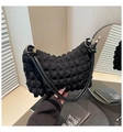 Detailed close-up of black popcorn textured shoulder bag with golden ring hardware - Black