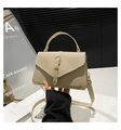 Detail of beige woven texture handbag with gold metal clasp and broad fabric strap - Khaki