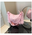 Close-up of pink popcorn textured handbag with golden ring hardware and tie handles - Pink