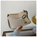 Detail of beige nylon crossbody bag featuring waterproof fabric and adjustable wide strap - Khaki