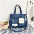 Dettaglio della borsa tote in tela bicolore con doppie tasche frontali e fibbie - Blu