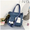 Dettaglio della borsa tote in nylon blu con multitasche e ciondolo a forma di rana - Blu Con Ciondolo
