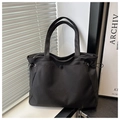 Detail of black nylon tote bag featuring decorative side drawstrings and smooth water-resistant finish - No Pendant / Black