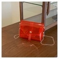 Minimalistische rote transparente PVC-Umhängetasche mit Goldkette auf einer Holzfläche - Rot